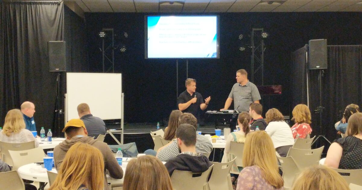 A speaker leading a training session for a room full of ministry leaders