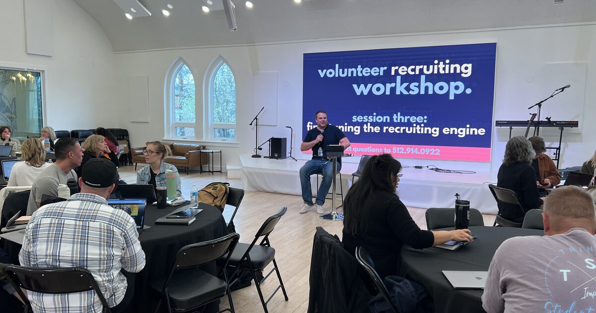 Church leaders gathered around tables during a volunteer recruiting workshop